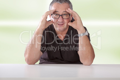 gray-haired man with glasses sitting at the table