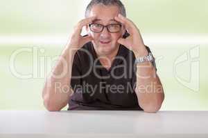 gray-haired man with glasses sitting at the table