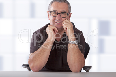 gray-haired man with glasses sitting at desk