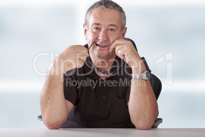 gray-haired man with glasses sitting at desk