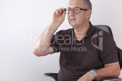 gray-haired man with glasses sitting at desk