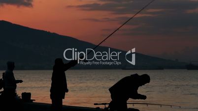 silhouette fisherman throws fishing tackles at morning