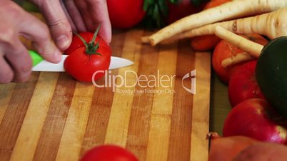 cutting a tomato on a wooden board