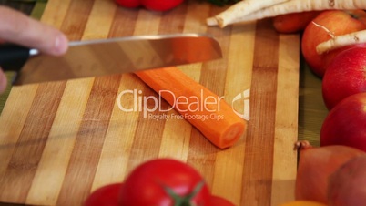 cutting a carrot on an wooden board