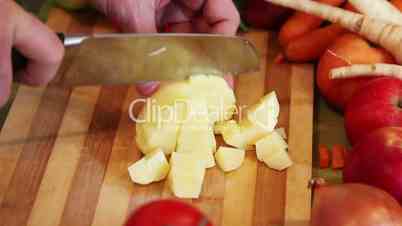 chopping a potato on an wooden board