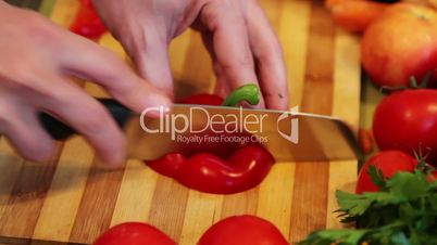 chopping the end of a red bell pepper