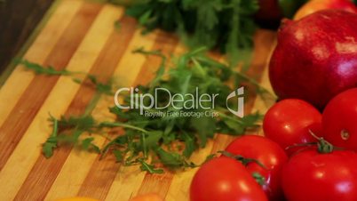 slow motion of arugula falling on an wooden board