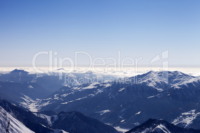 view from off-piste slope on snowy mountains in haze