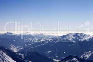 view from off-piste slope on snowy mountains in haze