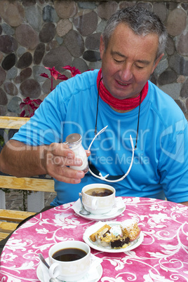 senior cyclist recovers with coffee and cake