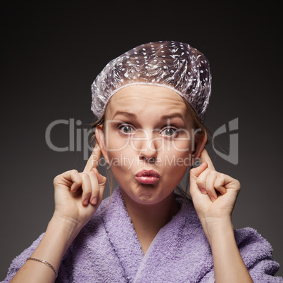 funny girl grimaces in a hat for a shower and a towel