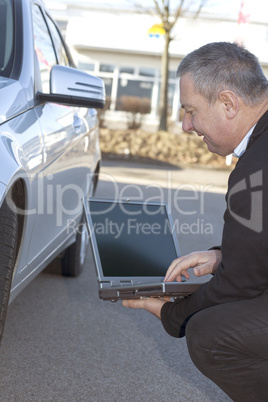 man with laptop controls the car