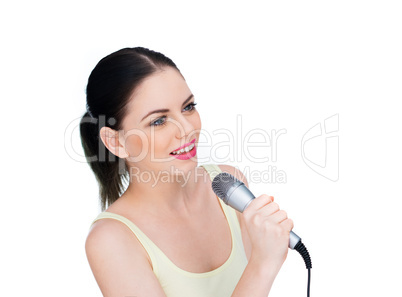 beautiful young woman singing into a microphone