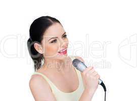 beautiful young woman singing into a microphone