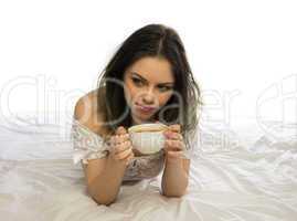 young woman daydreaming while enjoying coffee
