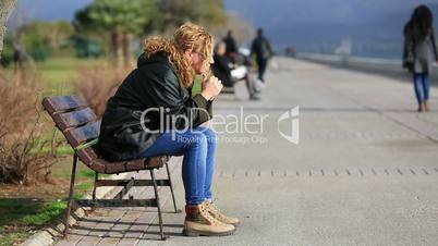 lonely blonde women sitting a bank