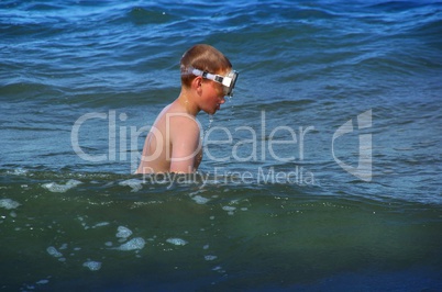 Junge mit Taucherbrille im Meer