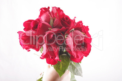 hand holding a bouquet of withered roses