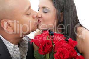 close up of couple kissing holding a bouquet of red roses