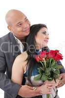 couple holding a bouquet of red roses looking at a copyspace