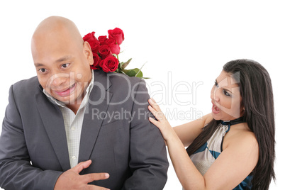 woman striking his boysfriend with a bouquet of red roses.  focu