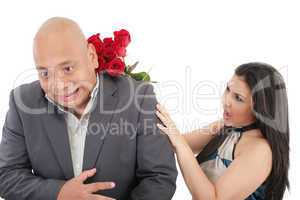 woman striking his boysfriend with a bouquet of red roses.  focu