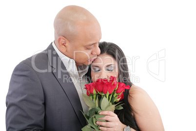 woman enjoys the smell given of a bouquet of roses. happy couple
