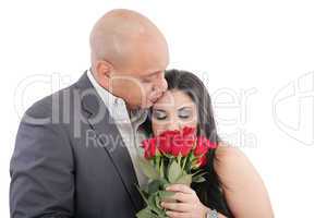 woman enjoys the smell given of a bouquet of roses. happy couple