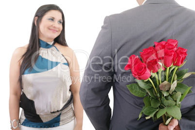 man hiding bunch of red roses behind his back to surprise his gi