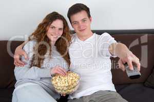 Junge Leute schauen TV und essen Popcorn