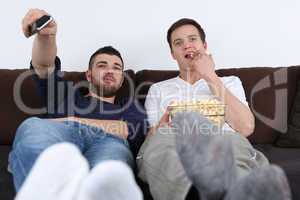 Junge Leute relaxen beim Fernsehen und essen Popcorn