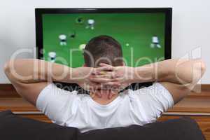 Junger Mann schaut Fußball im Fernsehen