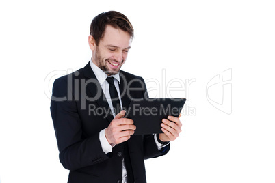 businessman smiling as he reads a tablet-pc