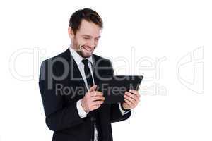 businessman smiling as he reads a tablet-pc