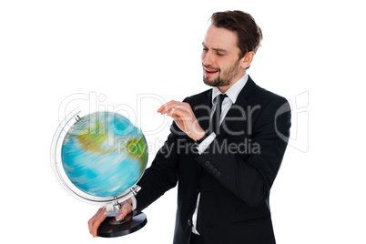 businessman spinning a globe of the world
