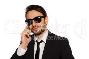 smiling businessman in sunglasses on his mobile
