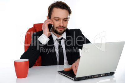 businessman talking on his mobile at his desk