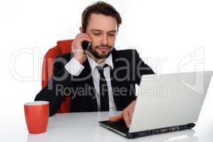 businessman talking on his mobile at his desk