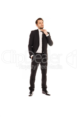 young businessman standing adjusting his tie