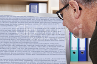 man with glasses looking at screen