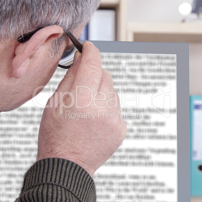 man with glasses looking at screen