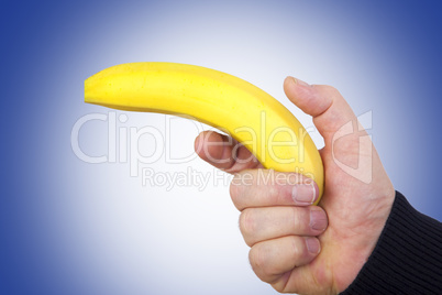 hand holds banana as a gun