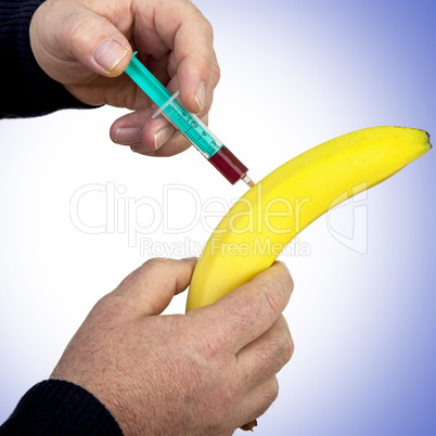 hand holding syringe on the banana