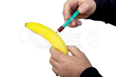 hand holding syringe on the banana