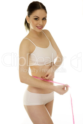 shapely slender woman measuring her waist