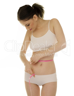slender young woman measuring her waist