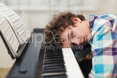 The boy has got tired to play the piano