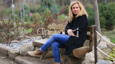 lonely blonde women sitting a bank