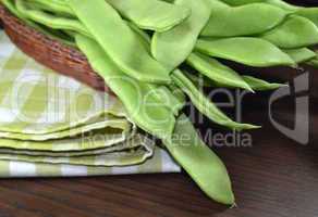 Raw green beans on a table cloth.
