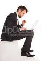businessman sitting on a stair working on a laptop